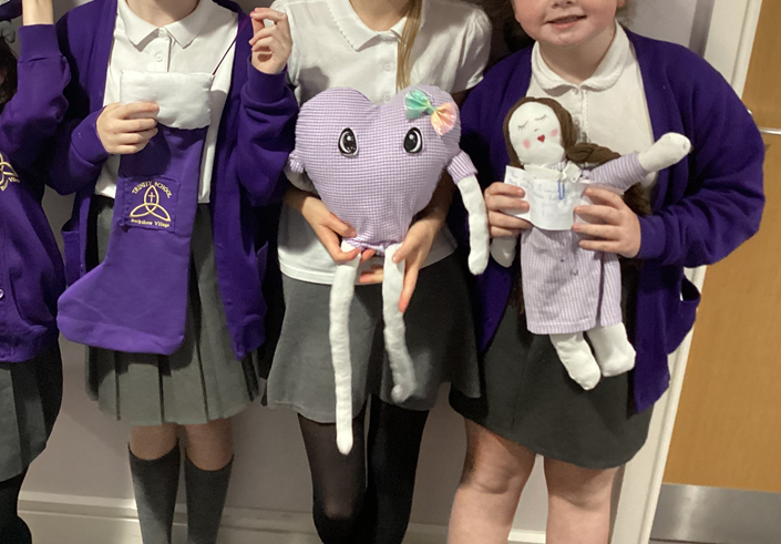 children holding sewing bee crafts